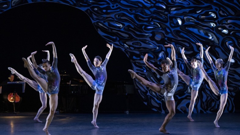 Mehrere Ballett-Tänzer auf der Bühne mit blauen Kostümen.