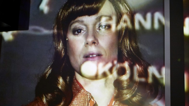 Das Gesicht von Katharina Blum auf einer großen Leinwand projiziert.