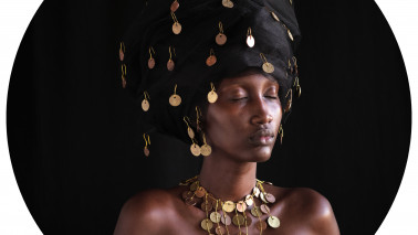 Porträtfotografie einer mit Münzen behangenen Frau.